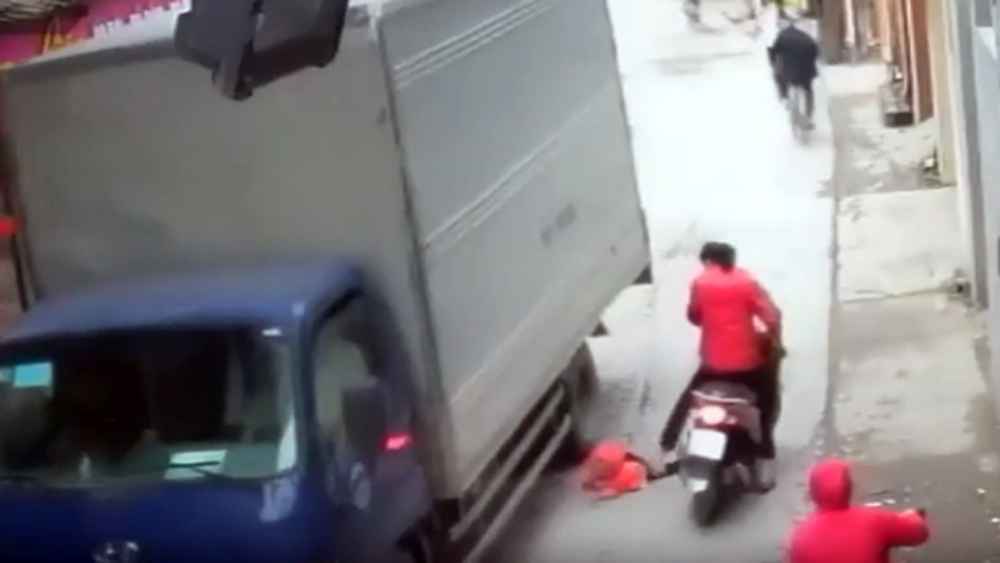 Hà Nội: Cháu bé ngã từ xe máy xuống đường suýt bị xe tải cán