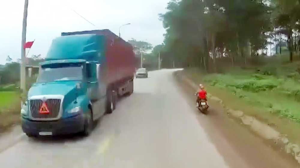 Sau tiếng còi hơi, mẹ chở con bằng xe máy ngã nhào trước mũi xe container